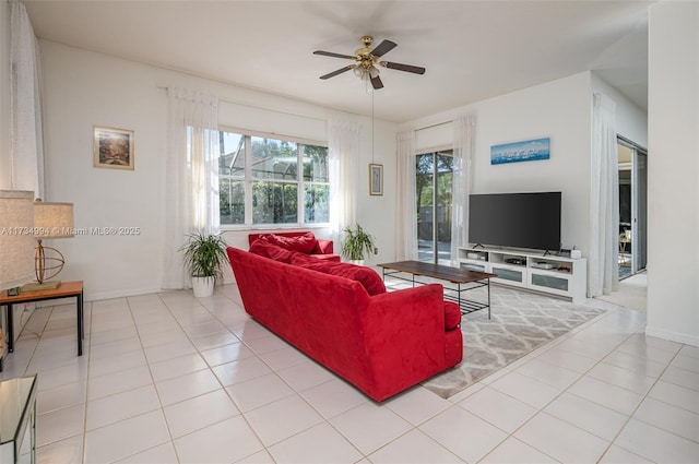 tiled living room featuring baseboards and ceiling fan