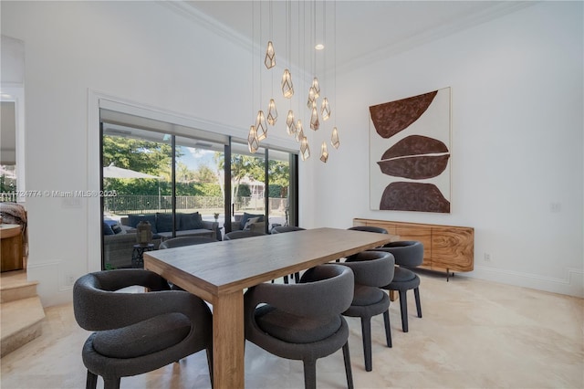 dining space with ornamental molding, a chandelier, and a high ceiling