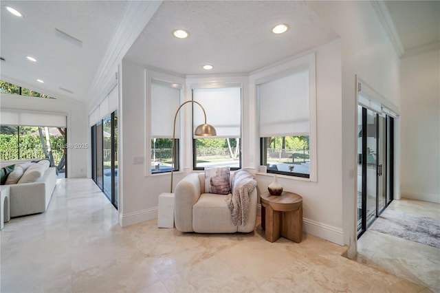 living area featuring vaulted ceiling, ornamental molding, and a textured ceiling