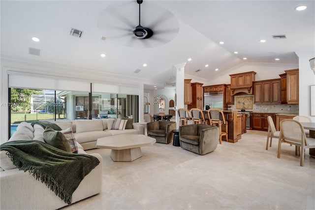 living room featuring vaulted ceiling, ornamental molding, and ceiling fan