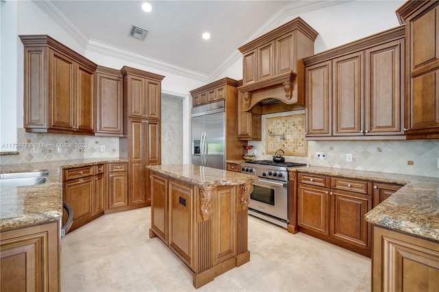 kitchen featuring a kitchen island, light stone countertops, and premium appliances