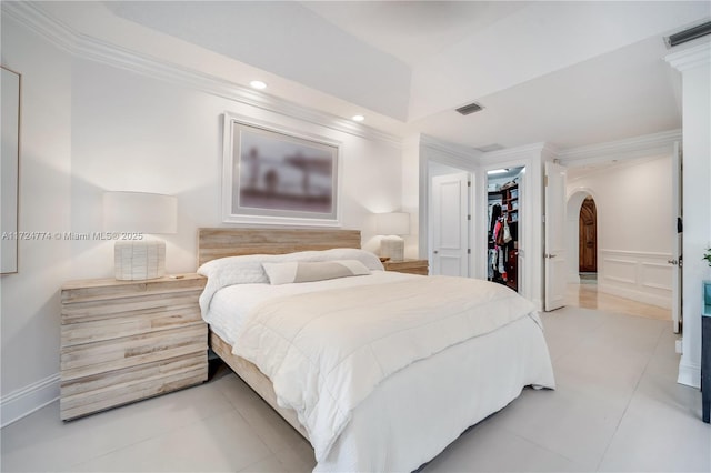 tiled bedroom featuring crown molding, a spacious closet, and a closet