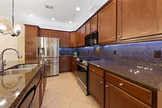 kitchen featuring sink, decorative light fixtures, appliances with stainless steel finishes, dark stone counters, and decorative backsplash