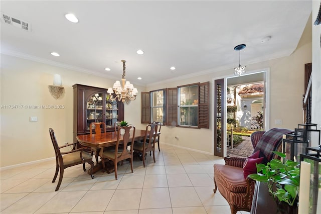 dining area featuring a notable chandelier, crown molding, and light tile patterned flooring