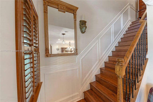 staircase with a chandelier