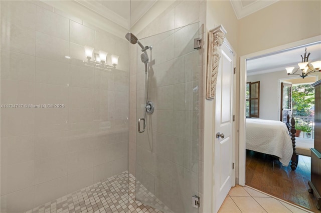 bathroom with tile patterned flooring, an enclosed shower, crown molding, and a notable chandelier