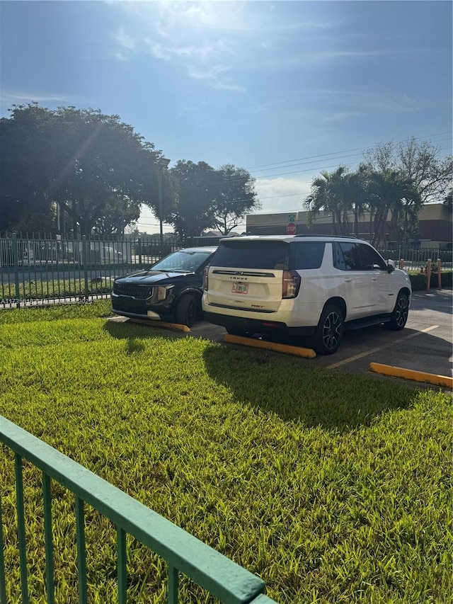 uncovered parking lot featuring fence