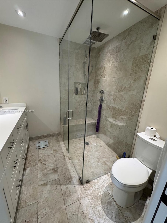 bathroom featuring toilet, recessed lighting, vanity, baseboards, and a shower stall