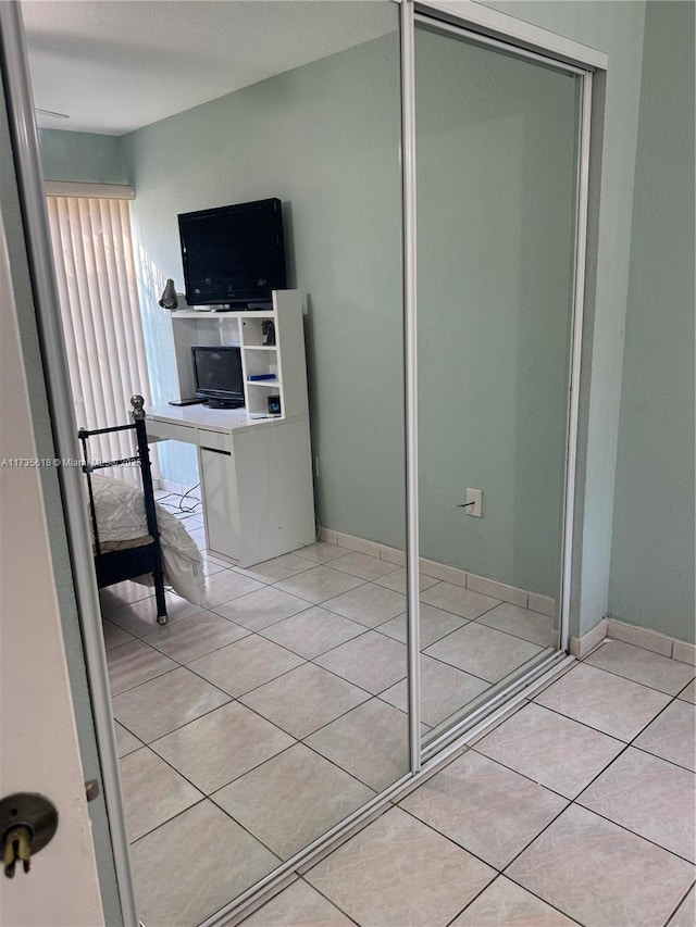 interior space with tile patterned flooring, baseboards, and a closet