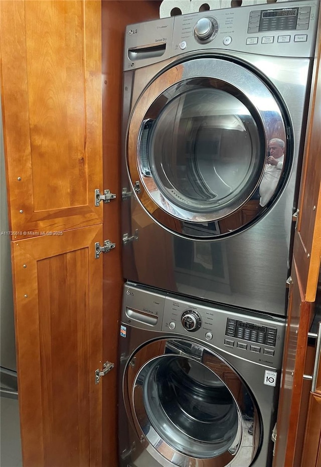 laundry area with stacked washer and dryer and laundry area