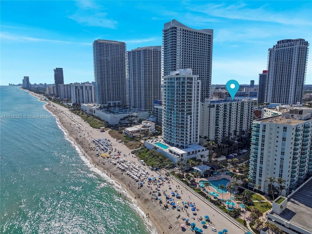 bird's eye view with a water view and a beach view