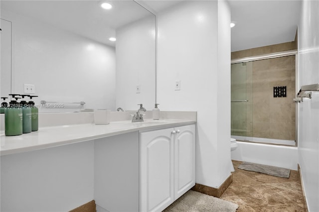 full bathroom featuring vanity, bath / shower combo with glass door, and toilet