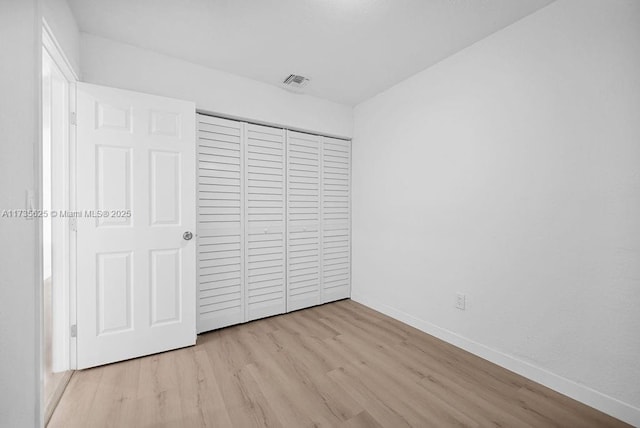 unfurnished bedroom featuring a closet and light hardwood / wood-style flooring