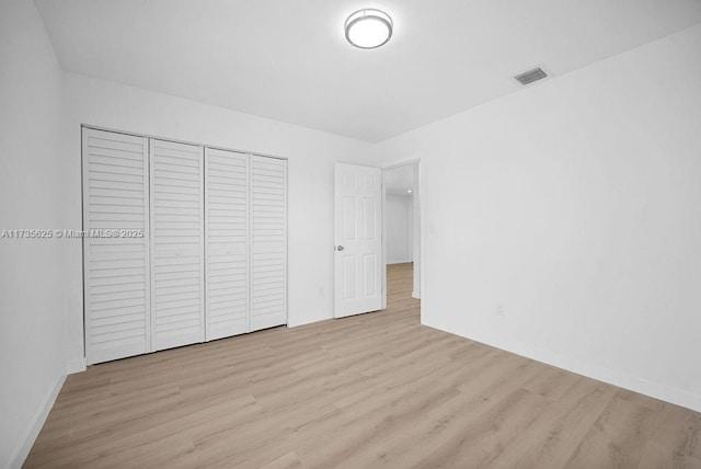 unfurnished bedroom featuring light wood-type flooring and a closet