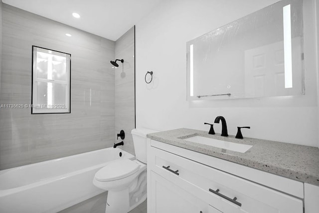 full bathroom with vanity, tiled shower / bath combo, and toilet