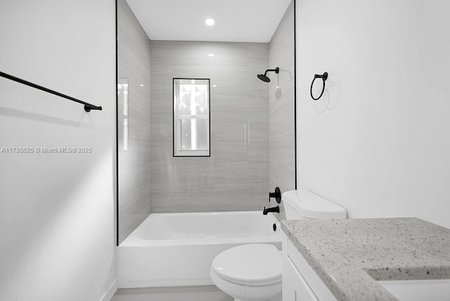 full bathroom with vanity, tiled shower / bath combo, and toilet