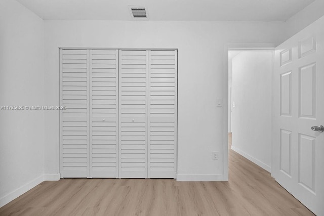 unfurnished bedroom featuring light hardwood / wood-style floors and a closet