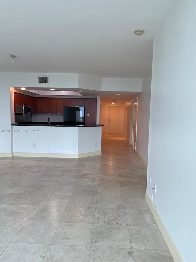 unfurnished living room featuring sink