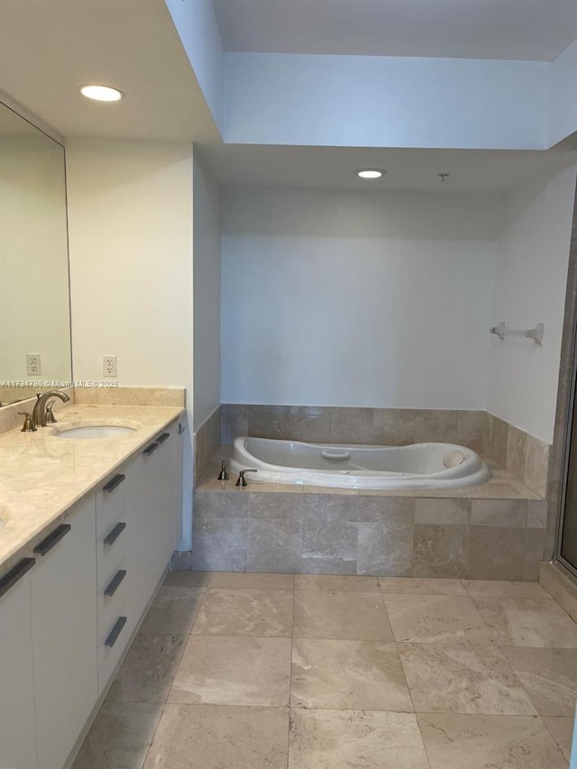 bathroom featuring vanity and tiled bath