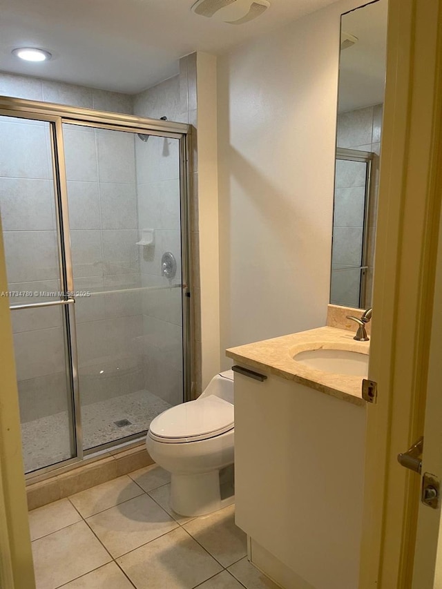 bathroom featuring vanity, toilet, an enclosed shower, and tile patterned flooring