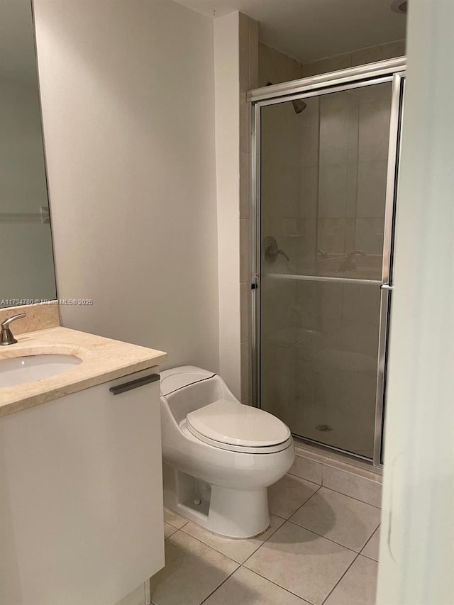 bathroom featuring vanity, tile patterned floors, toilet, and walk in shower