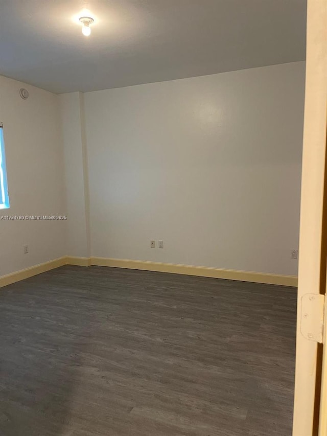 spare room featuring dark wood-type flooring