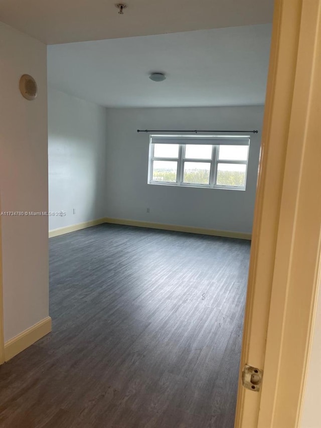 unfurnished room with dark hardwood / wood-style floors