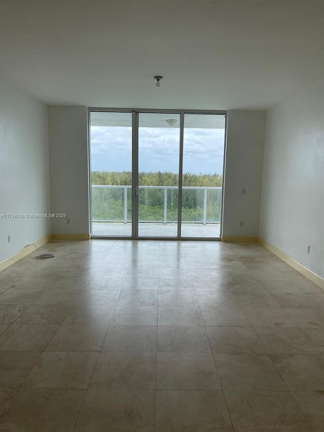 unfurnished room with expansive windows