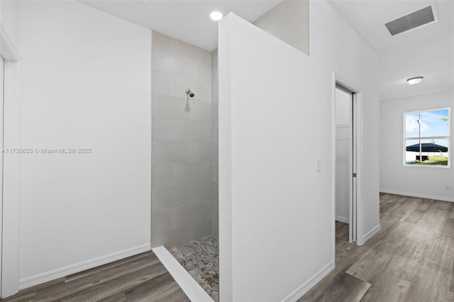 bathroom featuring tiled shower and hardwood / wood-style floors