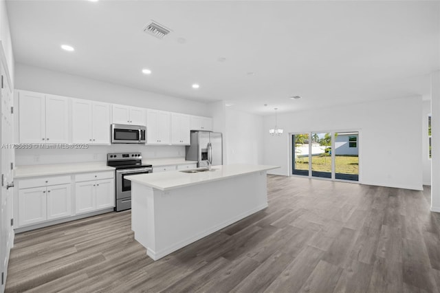 kitchen featuring stainless steel appliances, a kitchen island with sink, white cabinets, and light wood-type flooring