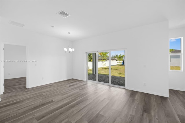 empty room featuring dark hardwood / wood-style floors and a notable chandelier