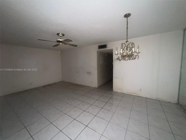 empty room featuring ceiling fan with notable chandelier