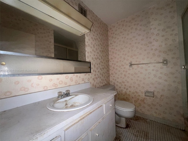 bathroom featuring vanity, a shower with door, tile patterned floors, and toilet