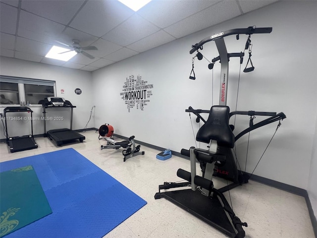 exercise room with a drop ceiling and ceiling fan