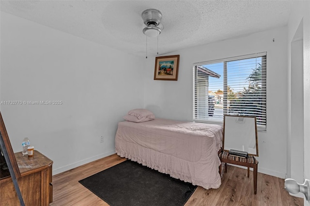 bedroom with wood-type flooring and a textured ceiling