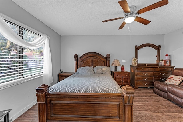 bedroom with ceiling fan, dark wood-type flooring, and a textured ceiling