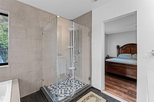 bathroom with wood-type flooring, a shower with door, and a textured ceiling