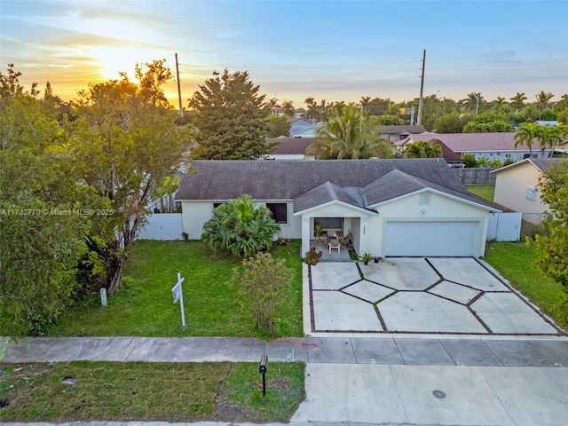 view of front of property with a garage and a yard