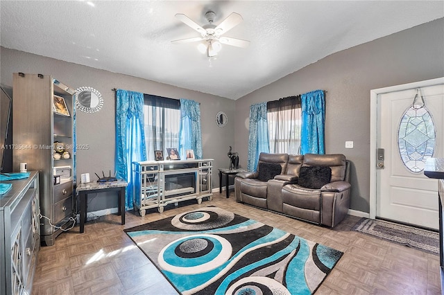 living room featuring ceiling fan, vaulted ceiling, a textured ceiling, and light parquet floors