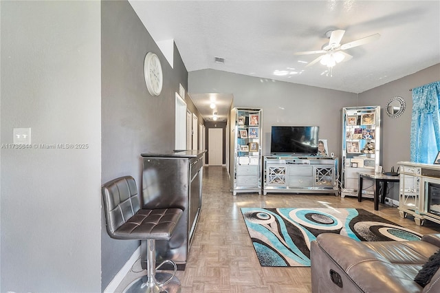 living room with ceiling fan, parquet flooring, and lofted ceiling