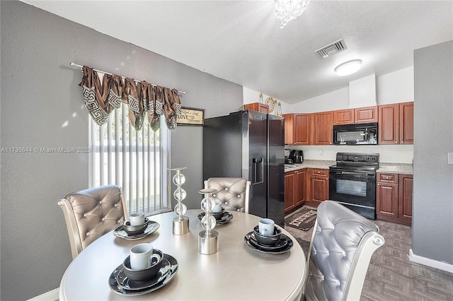 kitchen featuring vaulted ceiling, sink, black appliances, light parquet flooring, and a textured ceiling