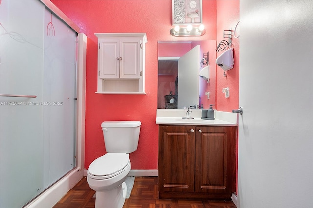 bathroom featuring vanity, an enclosed shower, parquet flooring, and toilet