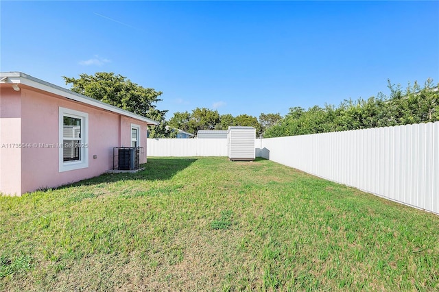 view of yard featuring a storage shed and central air condition unit