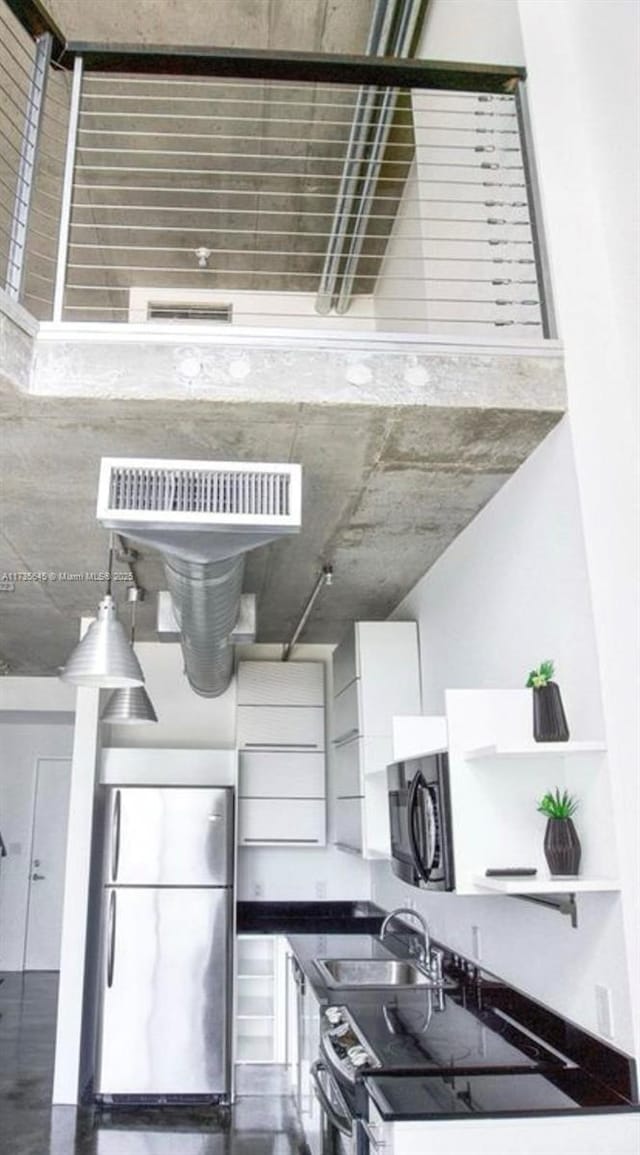 kitchen with stainless steel appliances, sink, and white cabinets