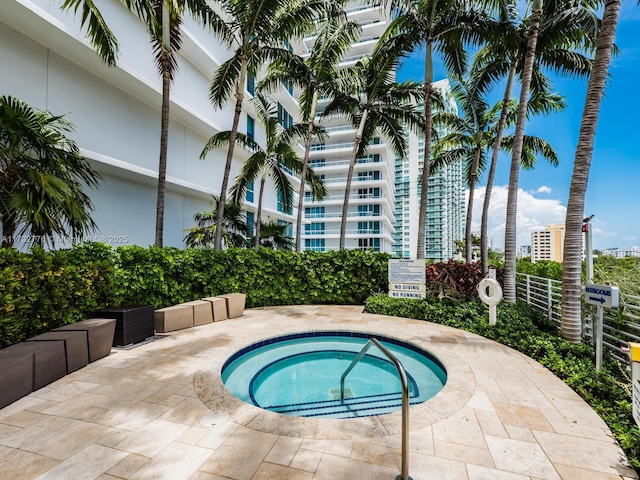 view of swimming pool with a hot tub and a patio area