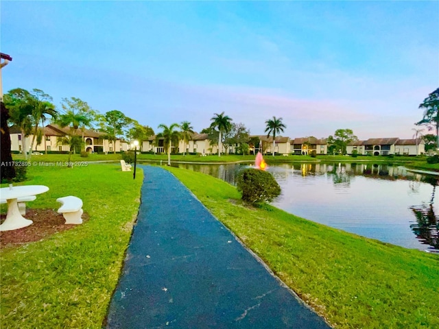 view of home's community with a lawn and a water view