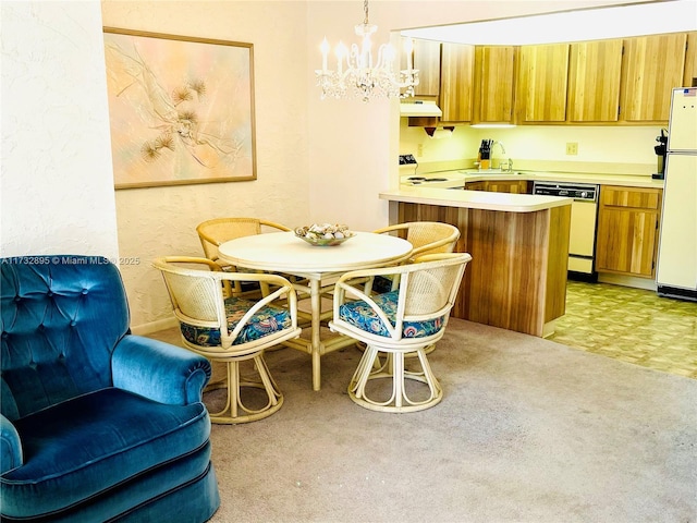 kitchen with a kitchen bar, hanging light fixtures, kitchen peninsula, dishwashing machine, and white fridge