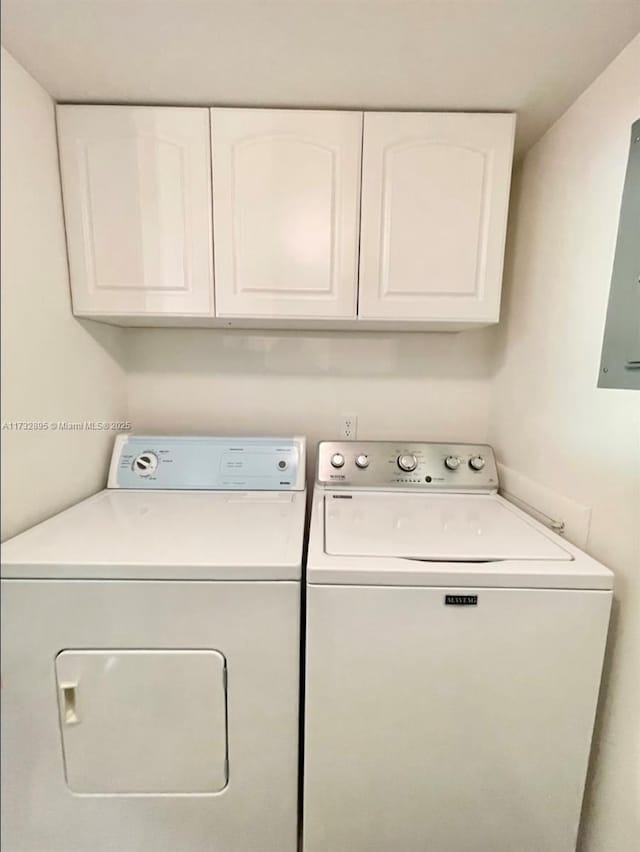 clothes washing area featuring cabinets and washing machine and clothes dryer