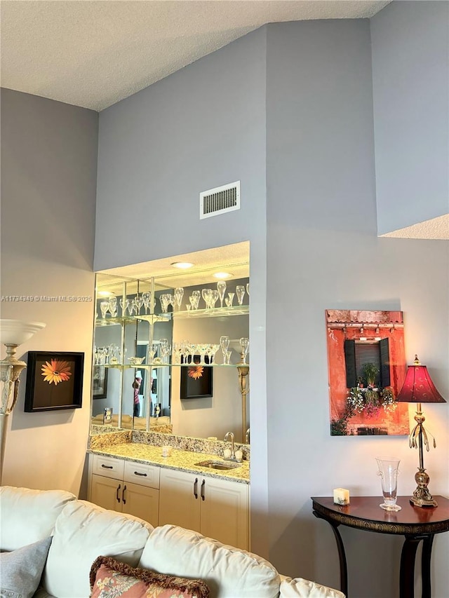 interior space with indoor wet bar and a textured ceiling