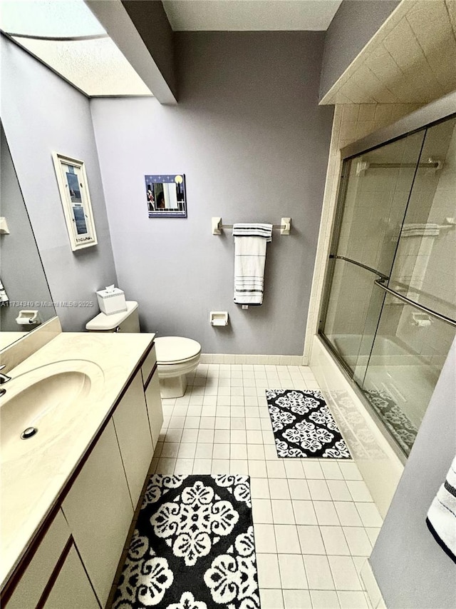 full bathroom featuring enclosed tub / shower combo, vanity, toilet, and tile patterned flooring